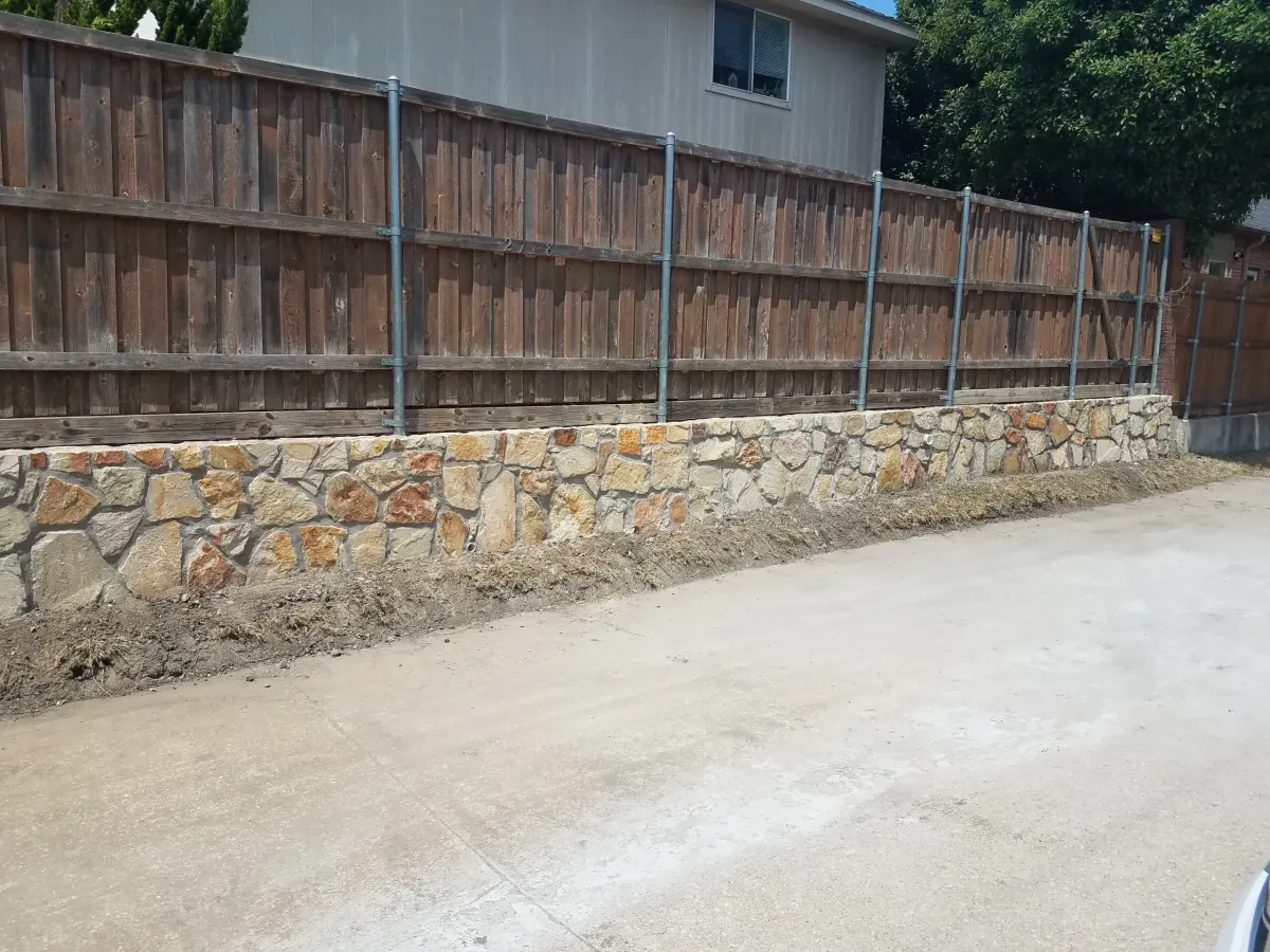 Granbury stone retaining wall built along a fence line in Frisco, TX Granbury stone retaining wall built along a fence line in Frisco, TX