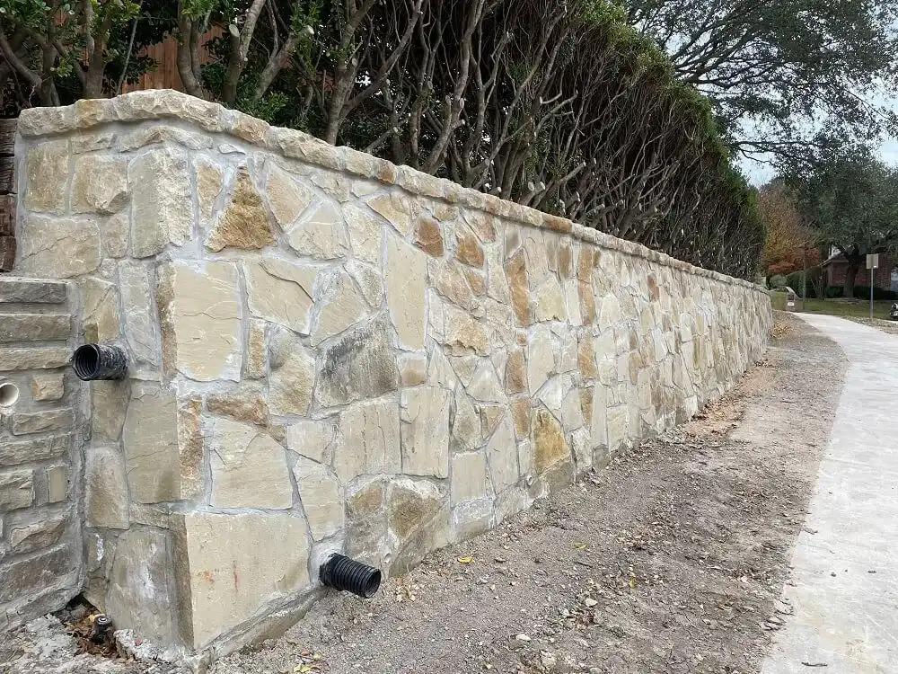 Granbury stone retaining wall with drainage on a DFW-area residential property Granbury stone retaining wall with drainage on a DFW-area residential property